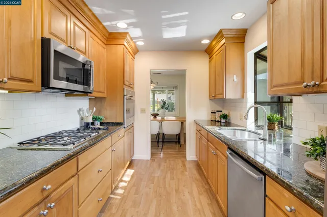 a kitchen with stainless steel appliances granite countertop a refrigerator and a sink