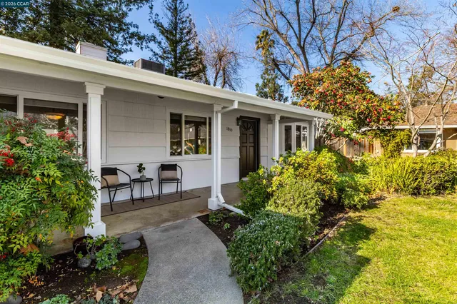 a view of a chair and table in backyard of the house