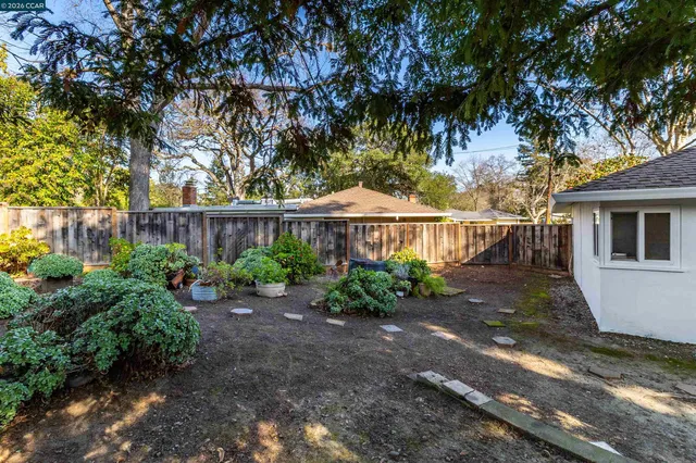 a view of a house with a yard and potted plants