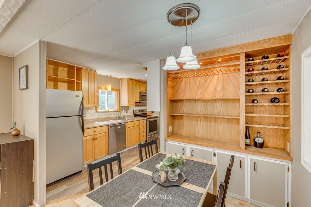 3318 206th Place Southeast Bothell, WA 98012 - Photo 20 of 35 a kitchen with stainless steel appliances granite countertop a refrigerator a sink dishwasher a dining table and chairs with wooden floor