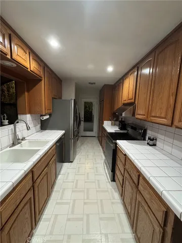 a kitchen with granite countertop a sink stove and cabinets
