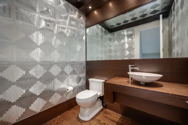 a bathroom with a granite countertop sink a toilet a mirror and shower