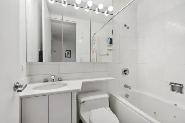 a bathroom with a toilet sink and mirror