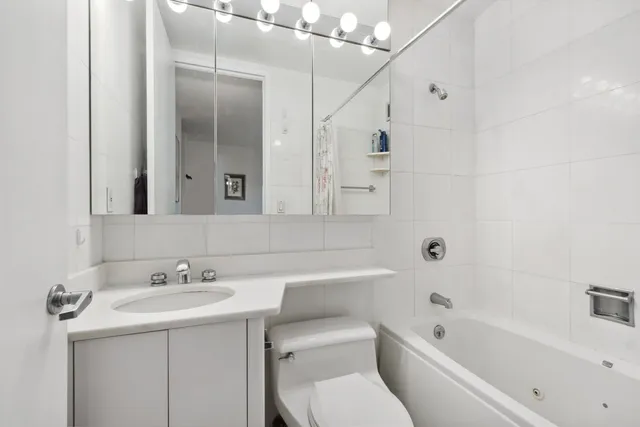 a bathroom with a sink toilet vanity and shower