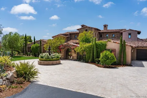 a front view of a house with a yard and potted plants