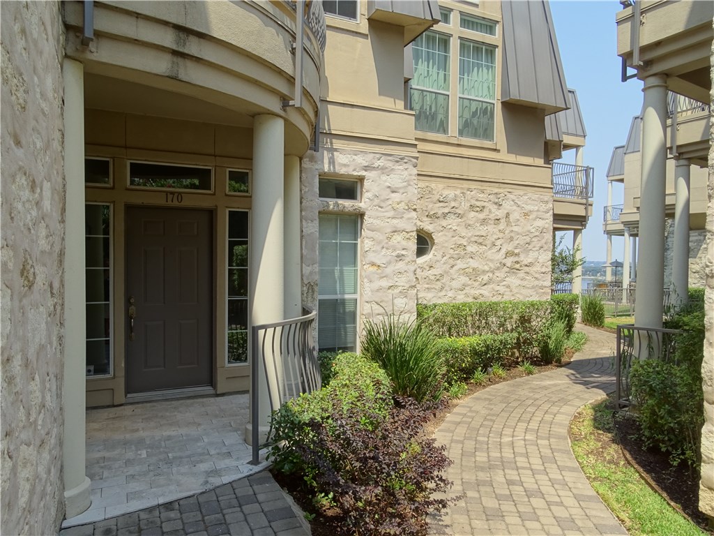2918 Ranch Road 620, Unit K170 Austin, TX 78734 - Photo 5 of 22 A charming paved walkway leads to the welcoming entry of this stone and stucco residence.