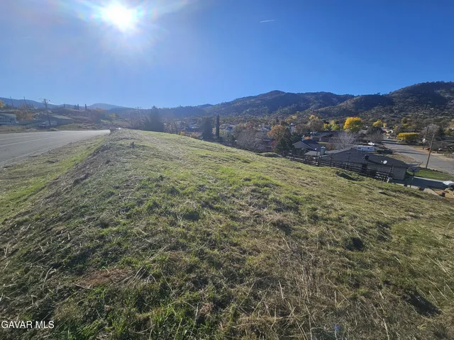 a view of a dry yard with mountains in the background