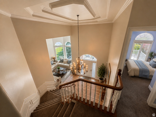 11902 Autumn Ridge Drive East Sandy, UT 84092 - Photo 15 of 20 Grand foyer featuring a two-story ceiling with decorative trim, a chandelier, and wood-finish flooring AI-staged or enhanced