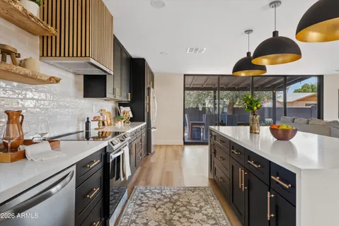 a kitchen with stainless steel appliances a sink a stove and a wooden floor