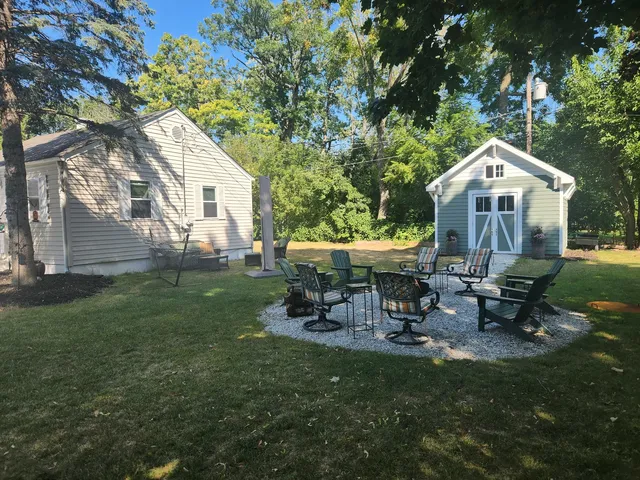 a view of a house with backyard and trees