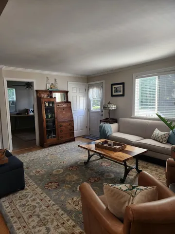 a living room with furniture a window and a table