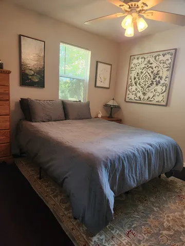 a bedroom with a bed dresser and window