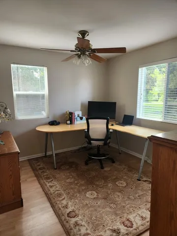 a reading room with wooden floor a lamp and a window