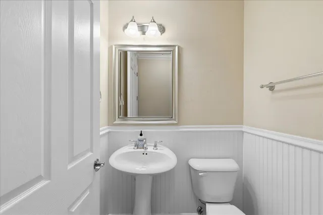 a bathroom with a toilet a sink and mirror