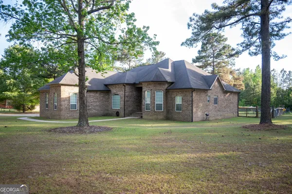 a view of a house with a yard and tree s