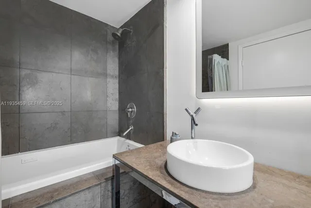 a bathroom with a granite countertop sink and a mirror