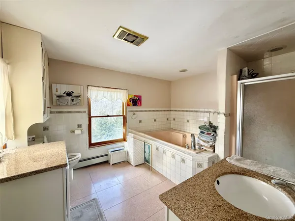 a bathroom with a tub sink and mirror