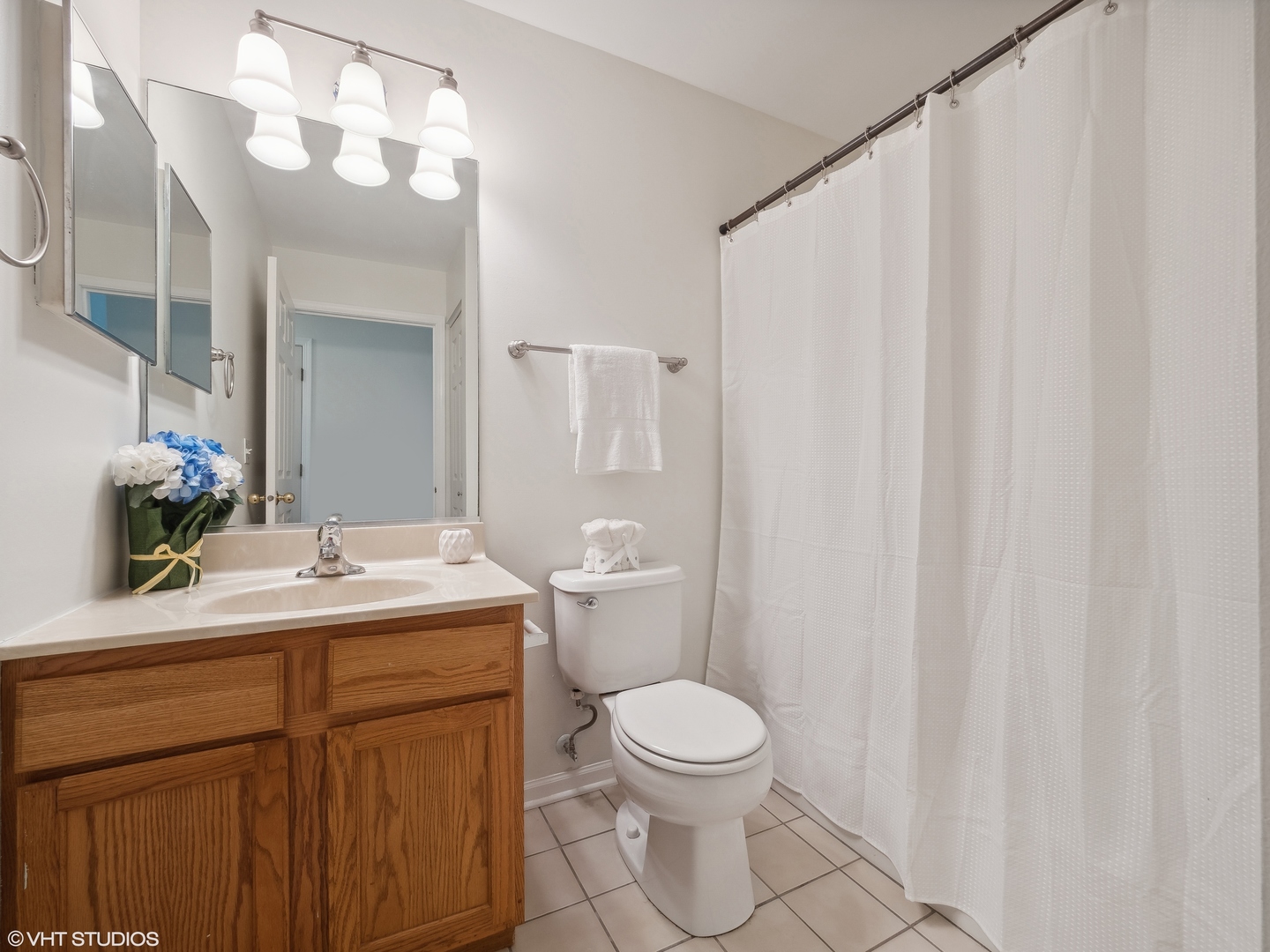 305 Buckingham Circle, Unit B Elgin, IL 60120 - Photo 10 of 20 a bathroom with a toilet a sink and a mirror