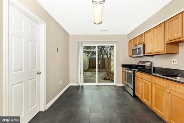 a view of a kitchen with wooden floor and windows