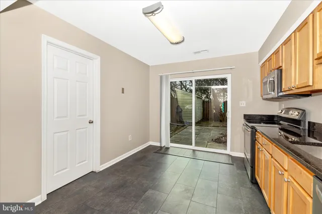 a view of a kitchen with stainless steel appliances granite countertop a stove top oven