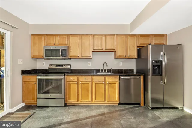 a kitchen with stainless steel appliances granite countertop a refrigerator stove and microwave