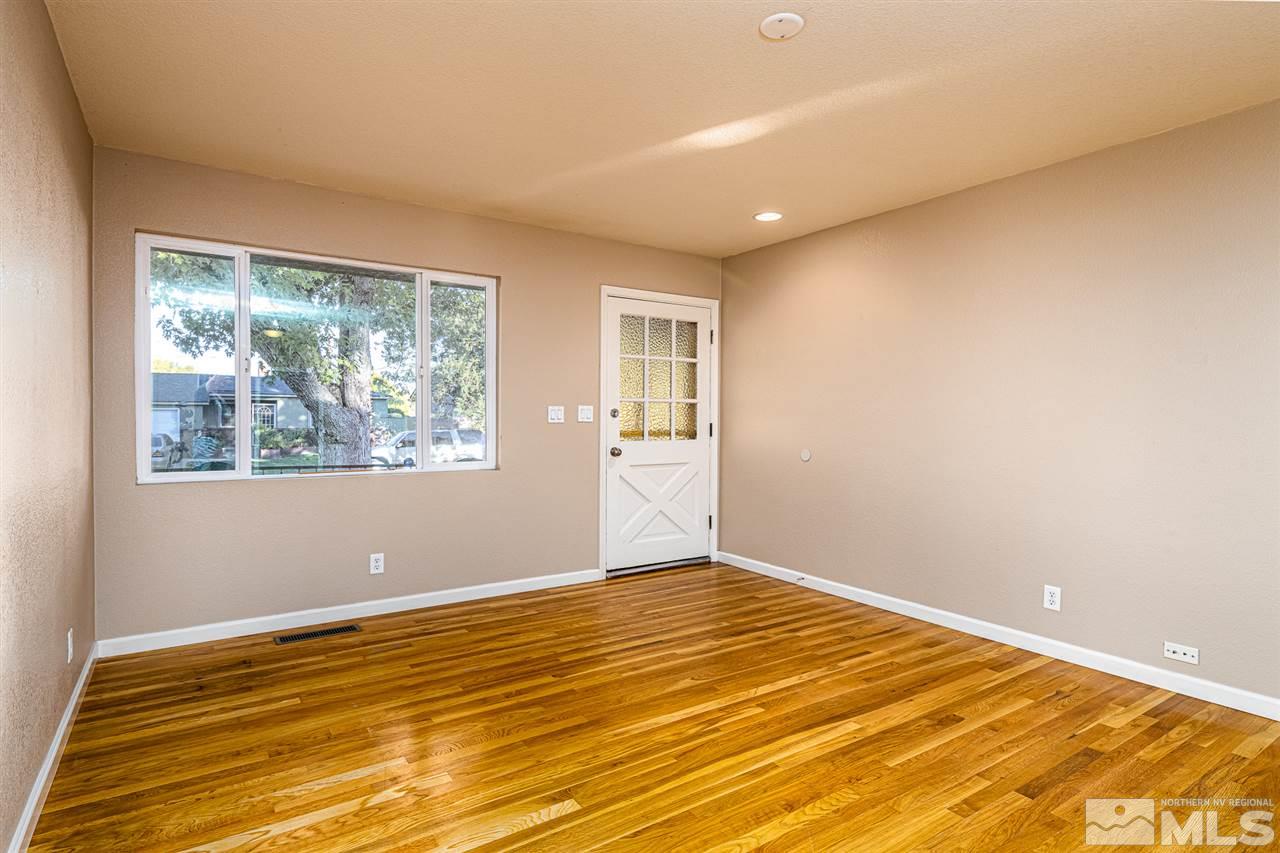 495 Ballentyne Way Reno, NV 89502 - Photo 4 of 25 a view of an empty room with wooden floor and a window