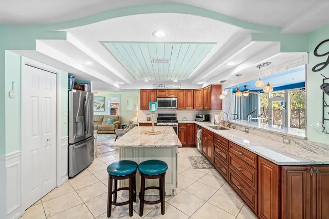 a large white kitchen with a large window and stainless steel appliances