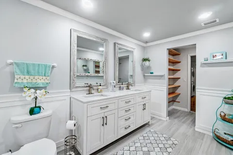 a bathroom with a sink a toilet and a mirror