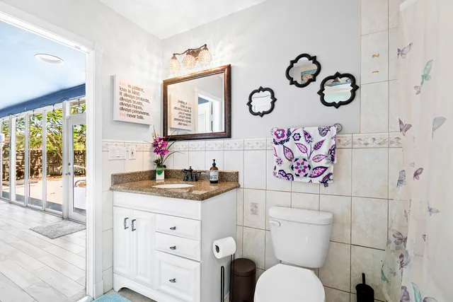 a bathroom with a granite countertop toilet sink and mirror