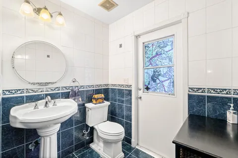 a bathroom with a sink toilet and a mirror