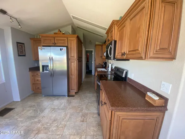 a kitchen with stainless steel appliances granite countertop a refrigerator and a stove