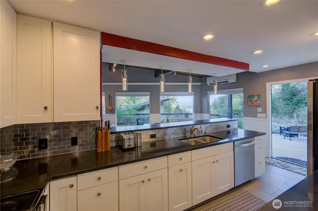 a kitchen with granite countertop a sink and white cabinets