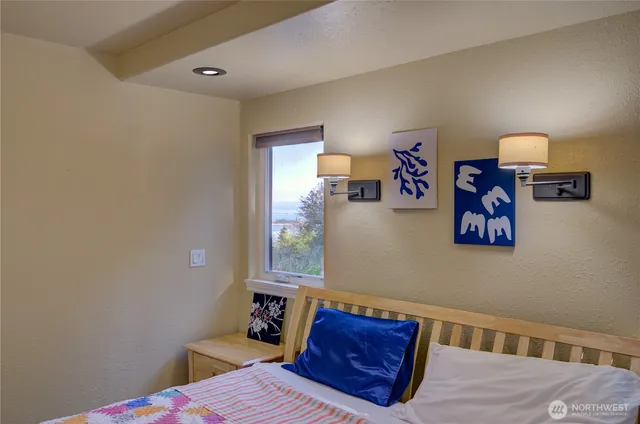 a bedroom with a bed and painting on the wall