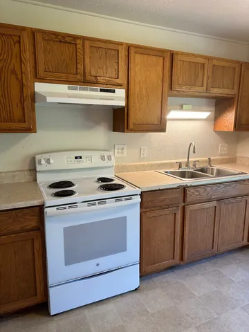 a kitchen with granite countertop white cabinets and appliances