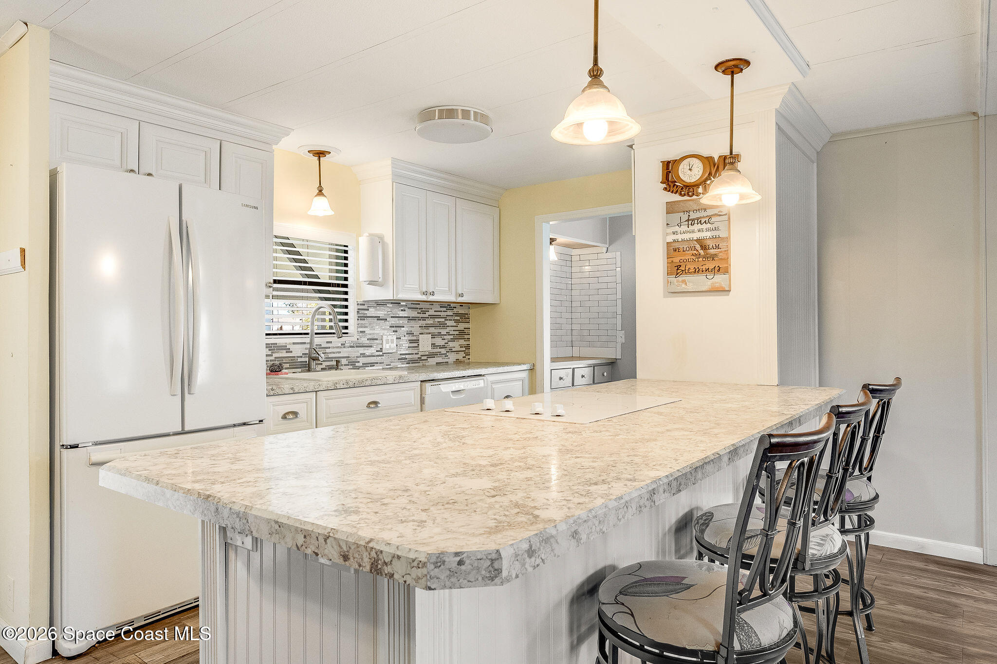 811 Silverthorn Court Barefoot Bay, FL 32976 - Photo 18 of 74 a kitchen with stainless steel appliances granite countertop a table chairs stove and refrigerator