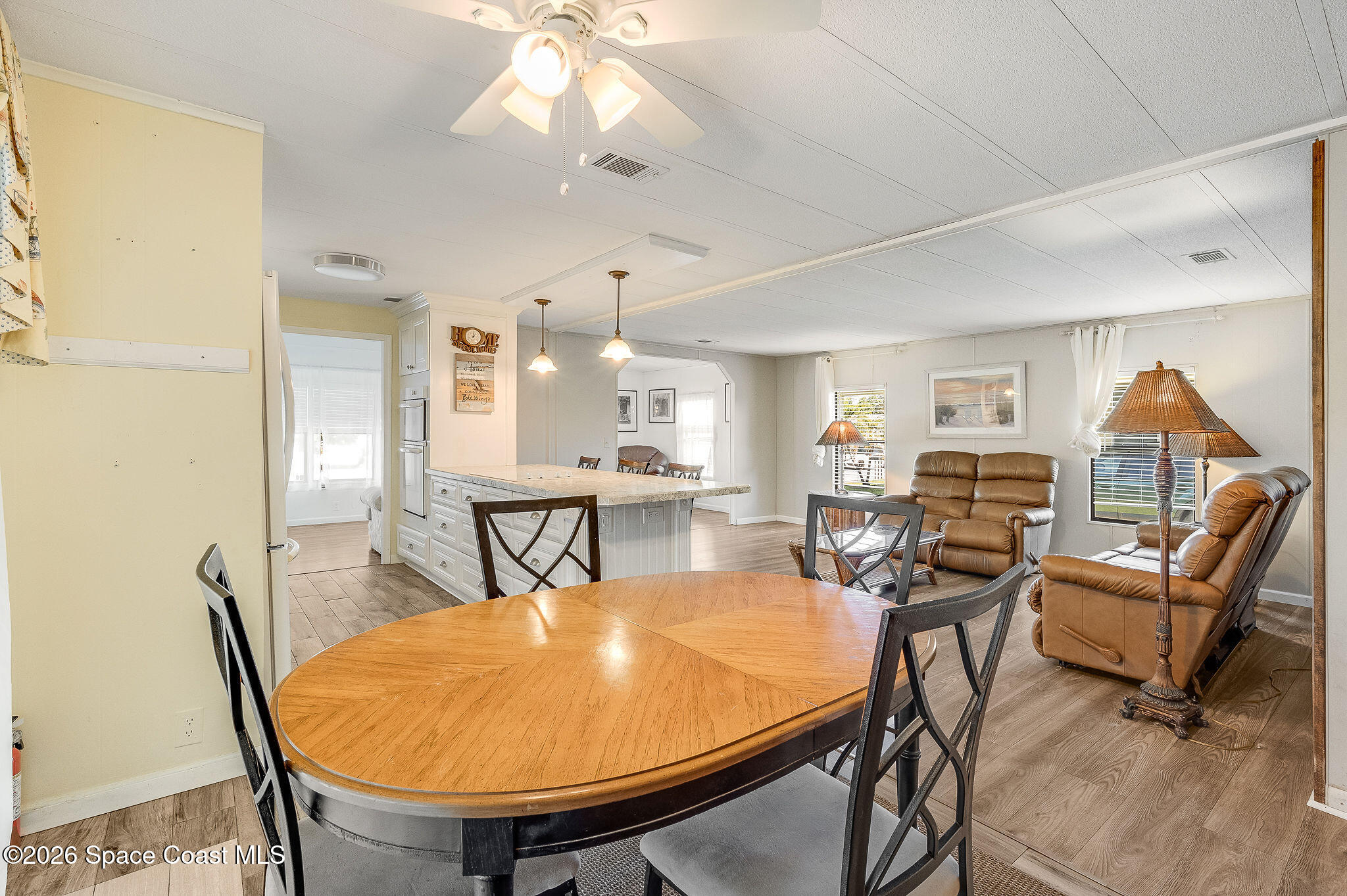 811 Silverthorn Court Barefoot Bay, FL 32976 - Photo 20 of 74 a view of a dining room with furniture and wooden floor