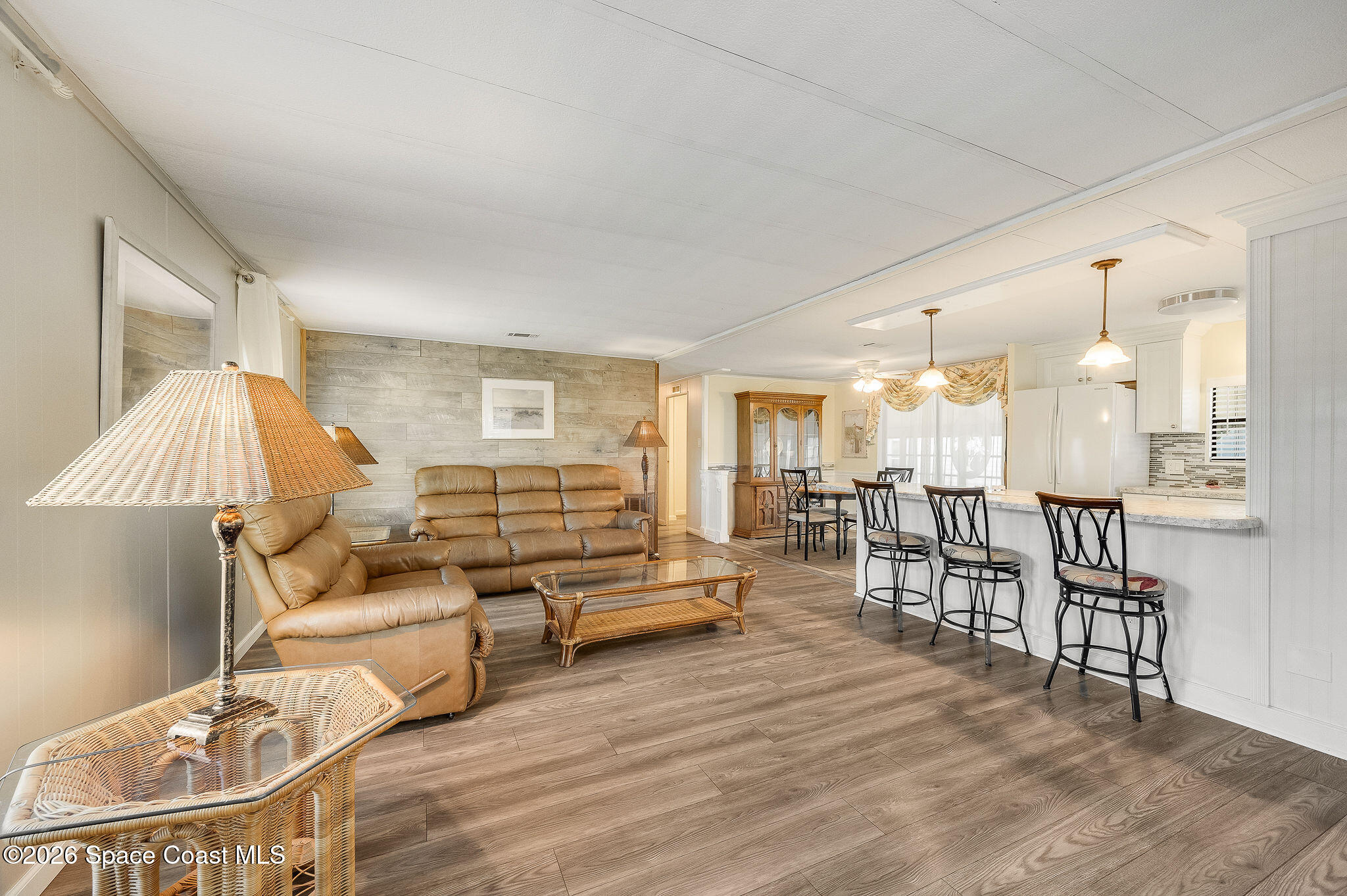 811 Silverthorn Court Barefoot Bay, FL 32976 - Photo 24 of 74 a living room with furniture and a dining table with wooden floor