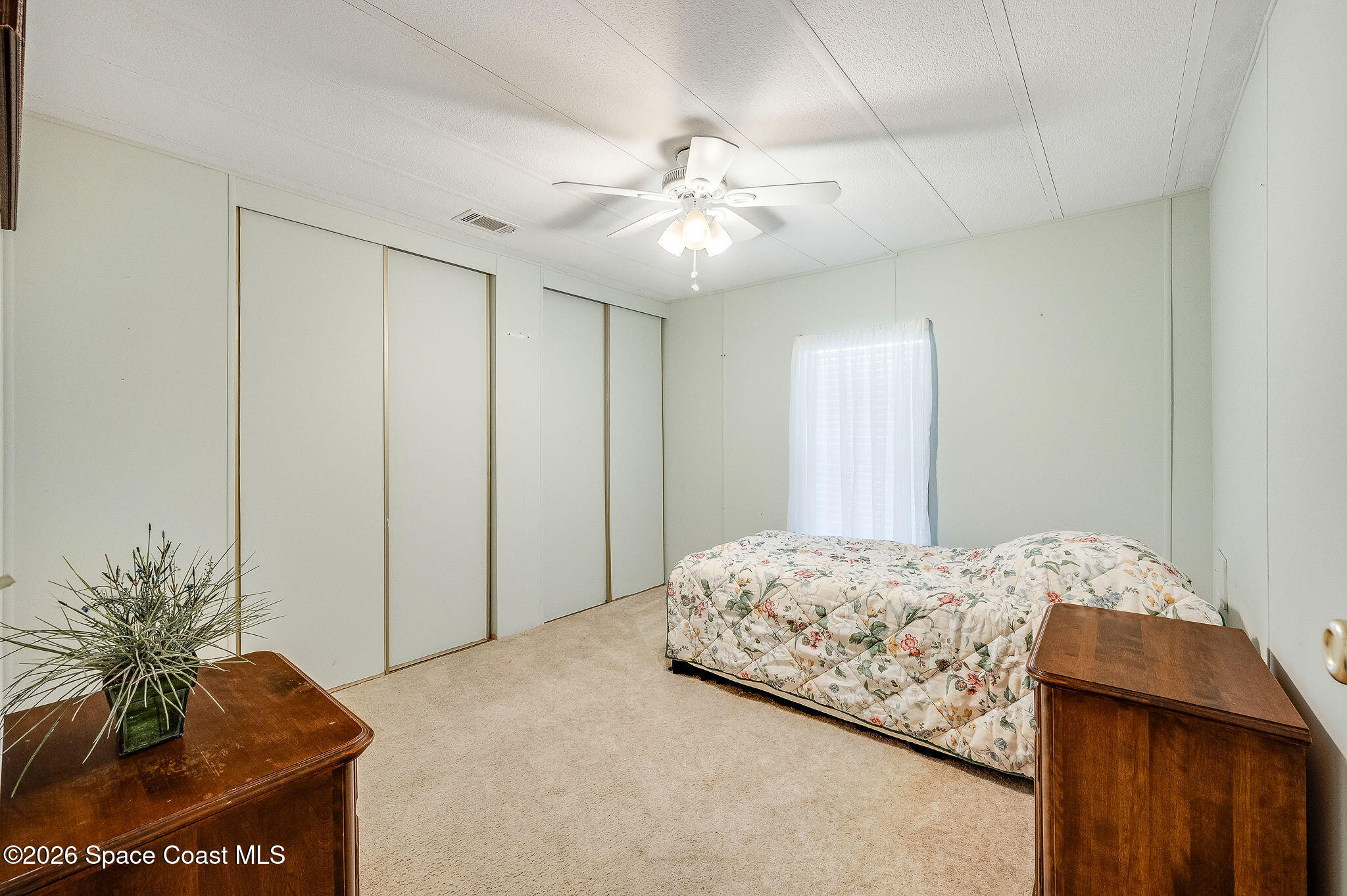 811 Silverthorn Court Barefoot Bay, FL 32976 - Photo 30 of 74 a bedroom with a bed and a chandelier