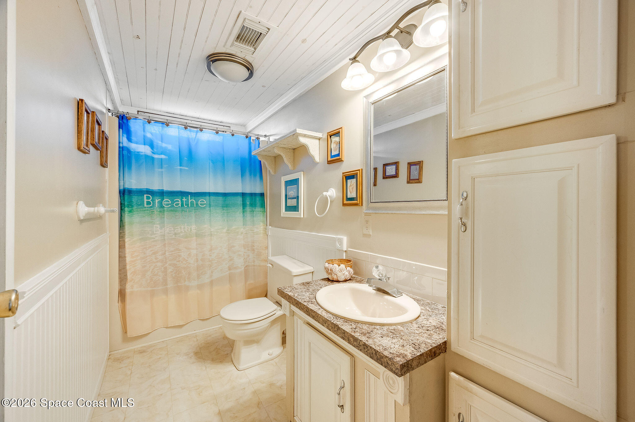 811 Silverthorn Court Barefoot Bay, FL 32976 - Photo 32 of 74 a bathroom with a granite countertop sink a toilet and shower