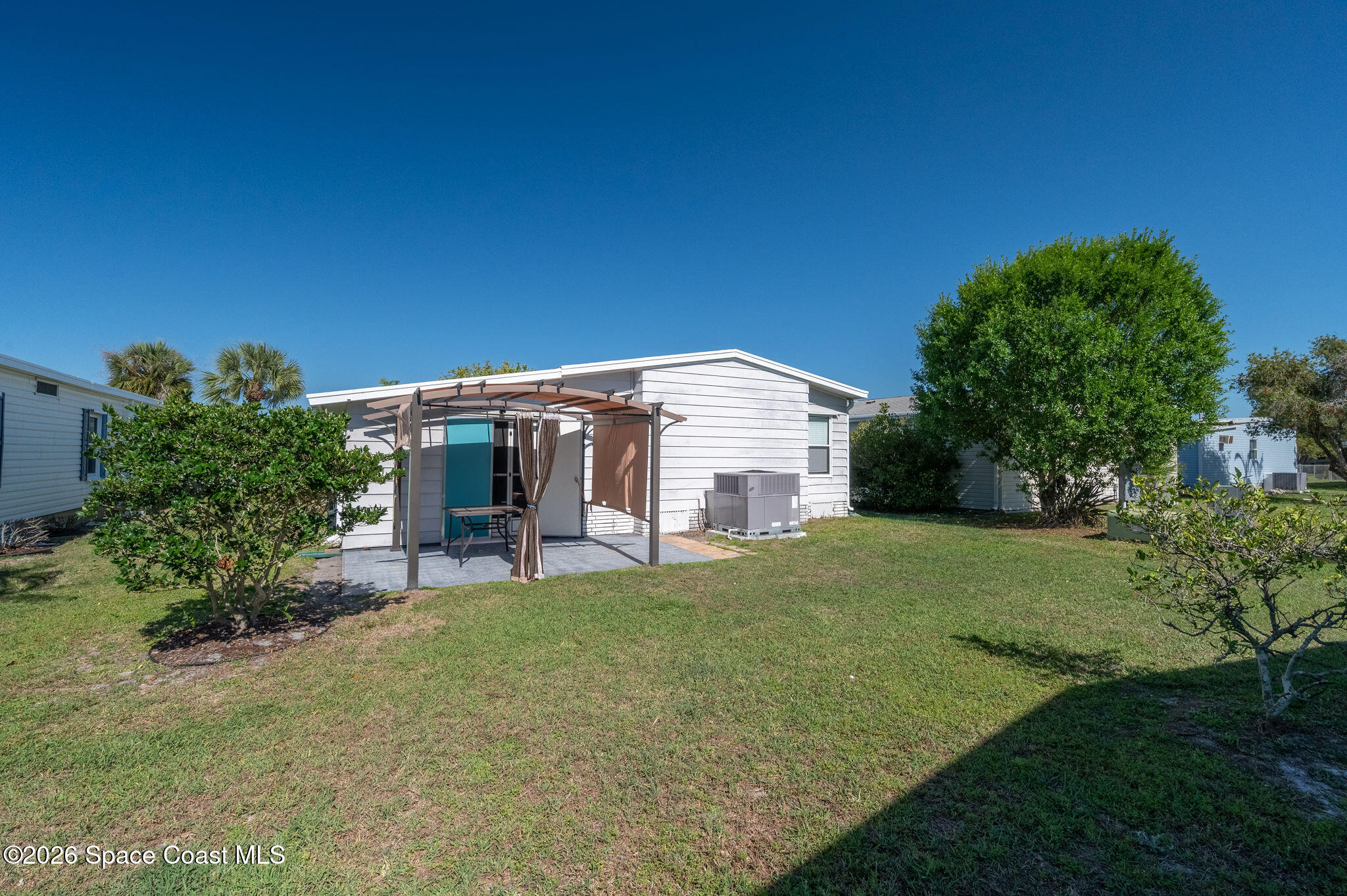 811 Silverthorn Court Barefoot Bay, FL 32976 - Photo 50 of 74 a view of a house with backyard and sitting area