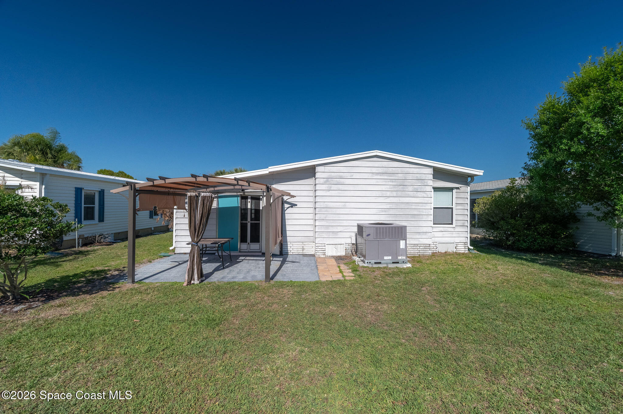 811 Silverthorn Court Barefoot Bay, FL 32976 - Photo 51 of 74 a backyard of a house with table and chairs