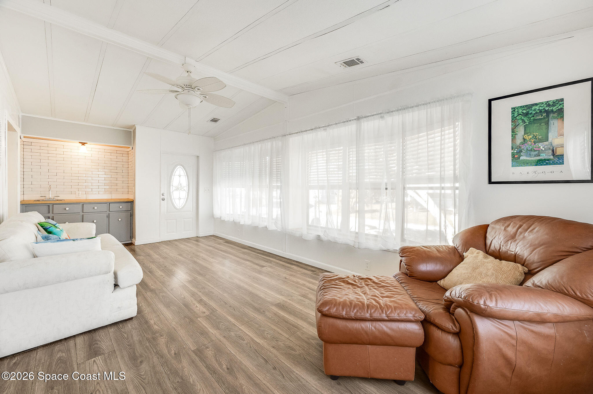 811 Silverthorn Court Barefoot Bay, FL 32976 - Photo 8 of 74 a living room with furniture and a large window