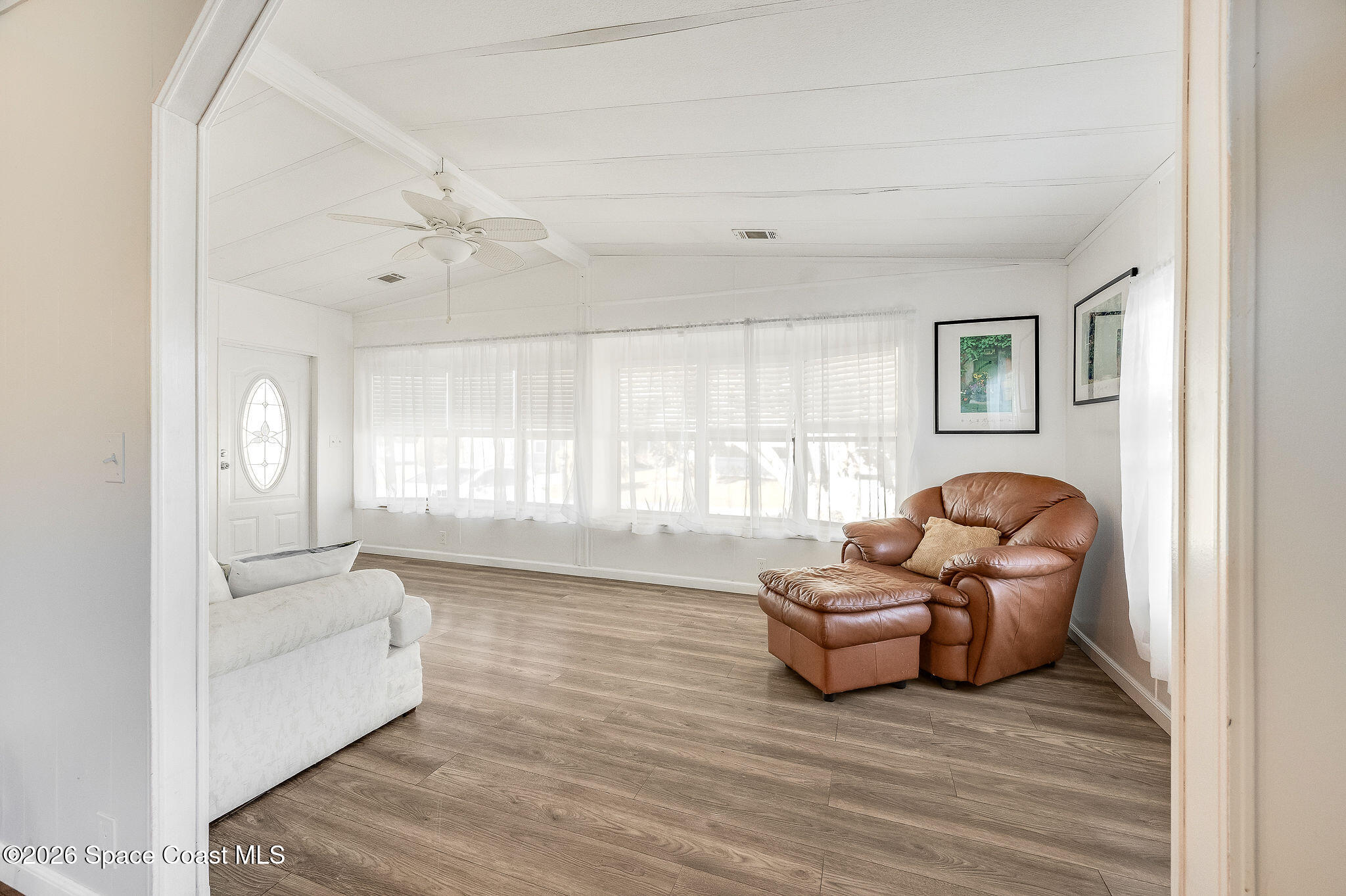 811 Silverthorn Court Barefoot Bay, FL 32976 - Photo 9 of 74 a living room with furniture and a large window