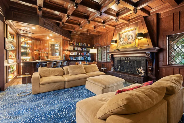 a living room with furniture a fireplace and a floor to ceiling window