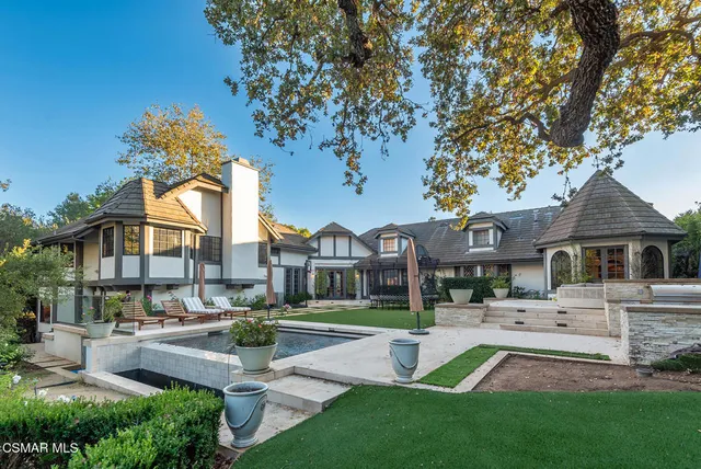 a front view of a house with garden and sitting area