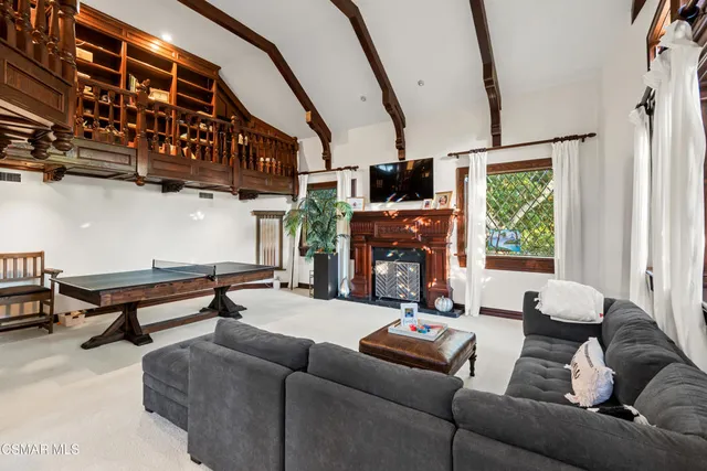 a living room with furniture a fireplace and a floor to ceiling window