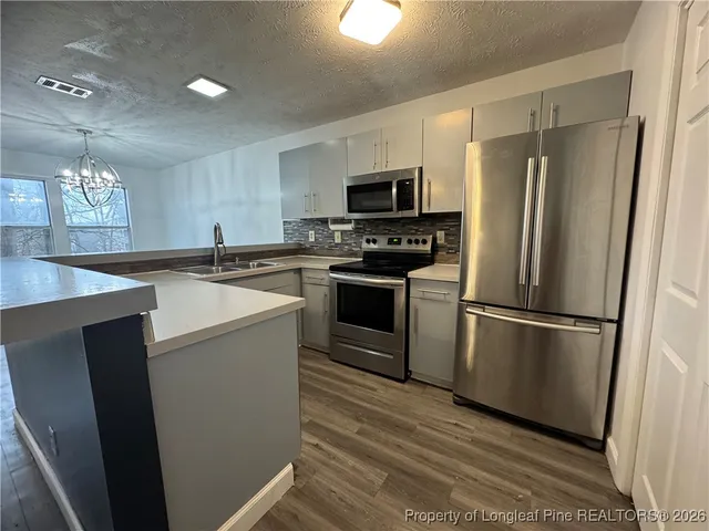 a kitchen with stainless steel appliances a refrigerator sink and microwave
