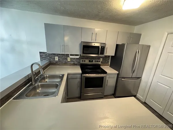 a kitchen with a sink a stove a microwave and refrigerator