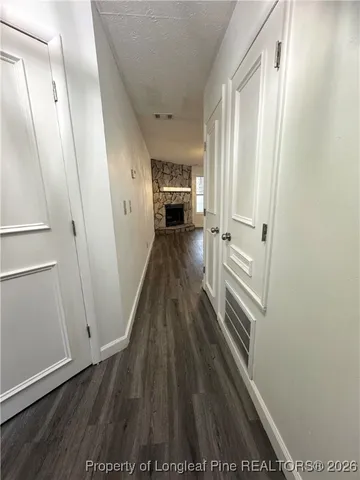 an open kitchen with wooden floor and a fireplace