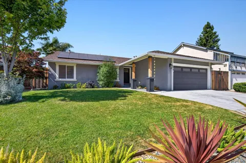 a front view of a house with yard and green space